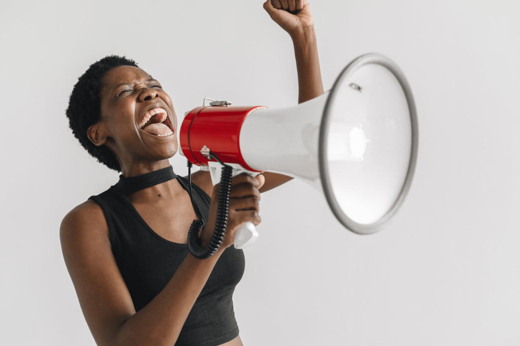 A black women shouting in a megaphone